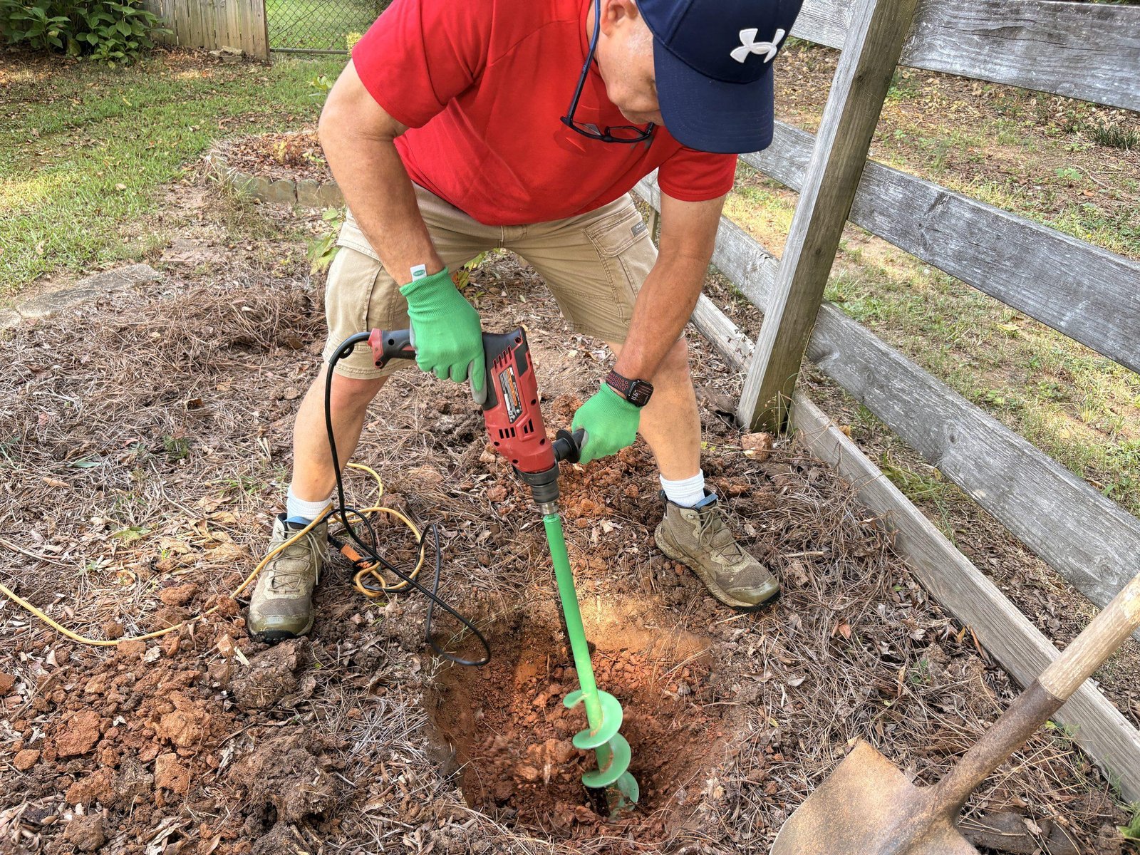 Bobby digging a planting hole with an auger at Bobby & Lynn’s Plant Farm.