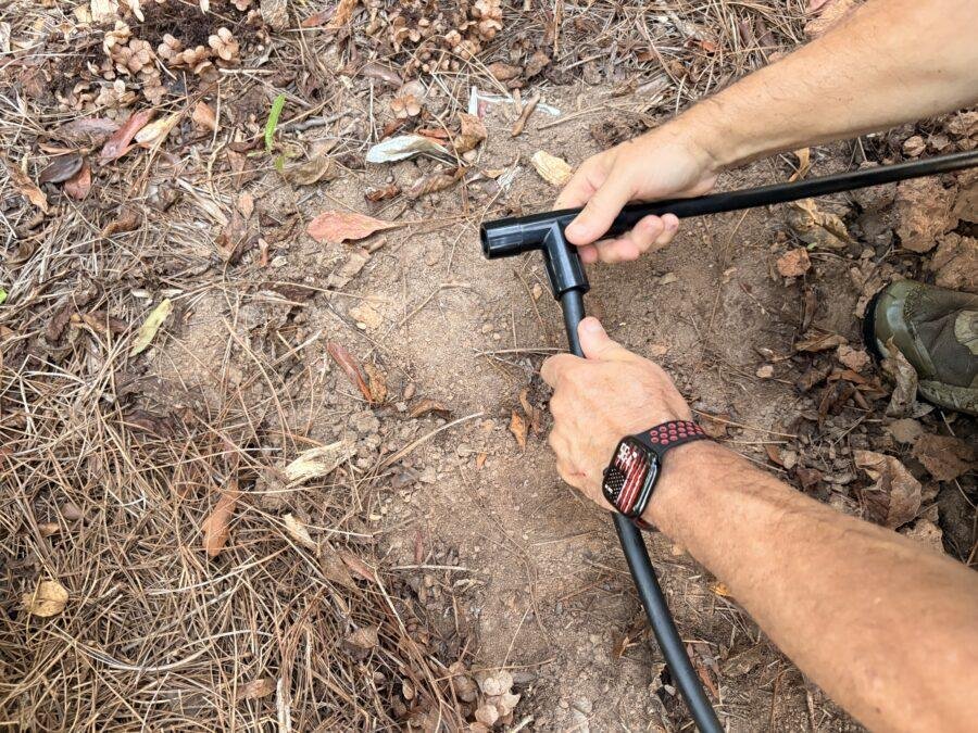 A picture showing the installation of a drip irrigation T